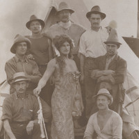 Image: group of men with centre man dressed up as a woman