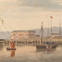 Image: A number of sailing ships are moored in a river. A scattering of buildings and a wharf are visible in the background