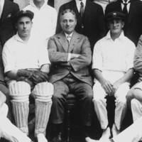 Image: A group of men in cricket uniforms poses for a photograph with other men dressed in suits