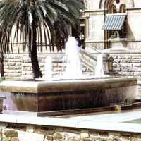 Image: stone fountain shaped like bathtub in front of stone buildings