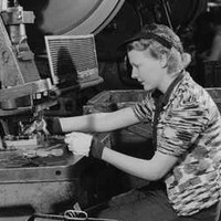 Image: A woman works at a machine to manufacture metal aircraft components