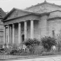 Image: Image: a stone building with six columned portico and decorative pediment
