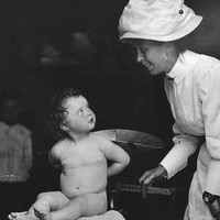 Baby Evangeline Gabriel being being weighed by a nurse 1908
