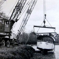 Image: boat being lifted from water by crane