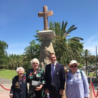 People standing in front of stone cross