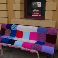 image: bench covered in knitting