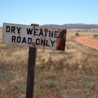 Image: Outback landscape and road with sign, stating 'Dry weather road only'