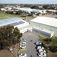 Image: aerial view of a group of hanger style buildings and car park