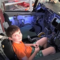 Image: young boy looking up from the cockpit of a plane