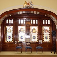 Image: A large alcove containing four intricate stained-glass windows with Australian and British motifs