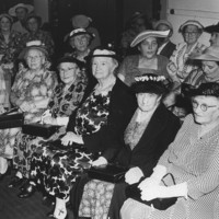 Image: Group of elderly women sitting in a room wearing hats