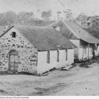 Image: Two gable roof, stone cottages sit adjacent to each other with the hills and gum trees of Lobethal in the background