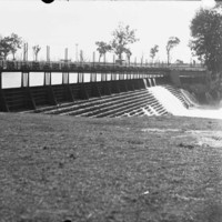 Image: A view a bridge over the river with water running down the steps located under the bridge