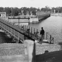 Image: Man standing on bridge over river