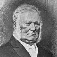 Image: The head and shoulders of a middle-aged man with white hair and mutton-chop sideburns