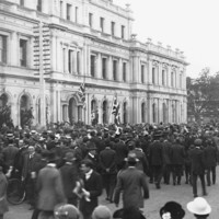 Image: crowd of people in front of large three story building