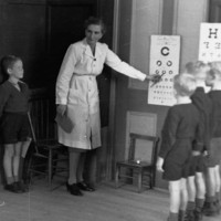Image: woman showing children eye chart