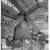 Image: A windmill is on display inside of a tall building.  There is a sign in the background that reads: Department of Agriculture 