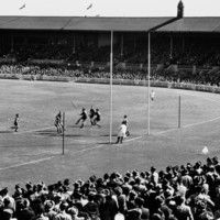 Image: A group of men play Australian Rules Football on an unidentified oval