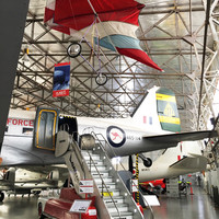 Image: group of planes in large hanger style building with flag draped from ceiling