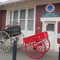 Image: Restored horse-drawn cart outside of a historical society building.