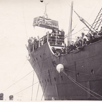 Image: casket being unloaded by crane from a ship