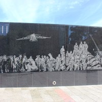 Wall with illustrations of men and machines displayed on it
