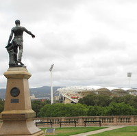 Image: Bronze statue of man pointing over stadium