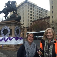 Image: two women stand in front of decorated statue of horse and rider