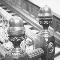 Image: A close up image of decorative carving on the newels (and the knobs that top them) of a large staircase
