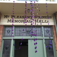 Image: garlands of crocheted violets hanging from building entrance
