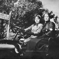 Image: two women pose for photograph in a motor car