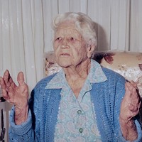 Image: elderly caucasian woman holds up her hands as she retells a story