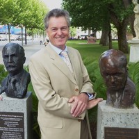 Image: Man standing between two bronze busts