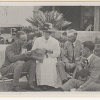 Image: A woman and three men sitting in a garden