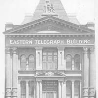 Image: Photograph of the front of a building. It has several columns and reads "Eastern Telegraph Building"