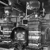 Image: stacks of wine bottles and large wine barrels with signs reading Hardy's