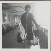 Image: Woman on a boat, posing for a photograph, holding onto the side rail