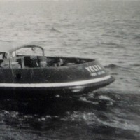 Image: A tugboat with the name ‘Yelta’ painted on its stern underway. The vague outline of a coast is visible in the distant background