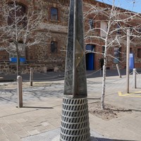 Image: metal post in front of large stone building