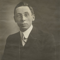 Image: Portrait of Rev. John Flynn. He is wearing glasses and a suit.
