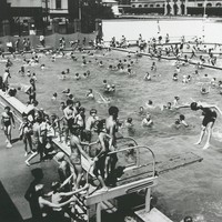 Image: large number of children in and around swimming pool