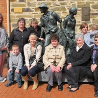 Image: family group pose with sculpture