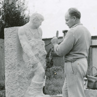 Image: black and white photograph of man sculpting in stone