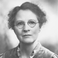 Image: Portrait photograph of a woman wearing glasses 