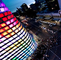 Image: The multimedia screen emits a rainbow of colors over nighttime pedestrians