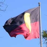 Image: flag with black top, red bottom and large yellow circle in the middle