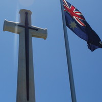 Image: Australian flag in front of cross monument, 2015.