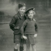 Image: boy and girl in tartan kilts and caps