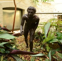 Image: bronze statue of a young naked boy in running pose